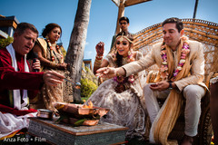 Indian bride and groom throwing rice into fire as a wedding ceremony ritual. paddy rice,indian bride and groom,indian wedding fashion,indian wedding ceremony