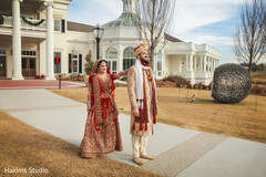 Indian bride and groom posing with their ceremony Lengha and sherwani outfits. indian wedding ceremony fashion,indian bride and groom,indian wedding traditional outfits