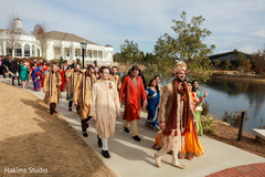Joyful Indian groom arriving at the wedding ceremony from the baraat procession .
