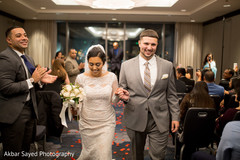 Lovely Indian bride on her white dress with her groom coming out from wedding ceremony. Lovely Indian bride on her white dress with her groom coming out from wedding ceremony.