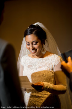 Lovely Indian bride on her white wedding dress saying her vows. Lovely Indian bride on her white wedding dress saying her vows.