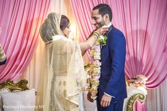 Indian bride putting flower garland to groom indian wedding reception,indian wedding reception photography,indian ride and groom