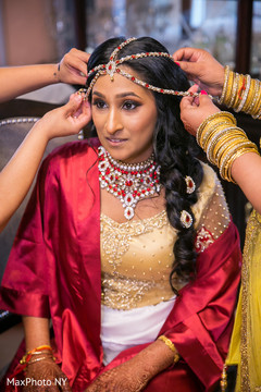 Indian bride being helped with jewelry Indian bride being helped with jewelry