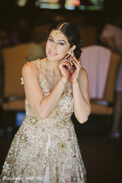 Dazzling Indian bride putting her earrings. Dazzling Indian bride putting her earrings.