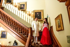 Indian bride and groom portrait walking down the stairs holding hands. Indian bride and groom portrait walking down the stairs holding hands.