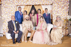 Adorable Indian bride and groom posing with family members. Adorable Indian bride and groom posing with family members.