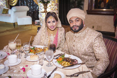 Lovely Indian bride and groom looking at camera while having lunch. Lovely Indian bride and groom looking at camera while having lunch.