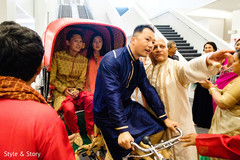 Indian groom arriving at the baraat celebration on a pulled rickshaw. Indian groom arriving at the baraat celebration on a pulled rickshaw.