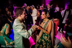 Indian bride and groom dancing holding hands at their pre-wedding celebration. Indian bride and groom dancing holding hands at their pre-wedding celebration.