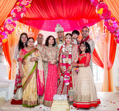 graceful Indian bride and groom posing with family. graceful Indian bride and groom posing with family.