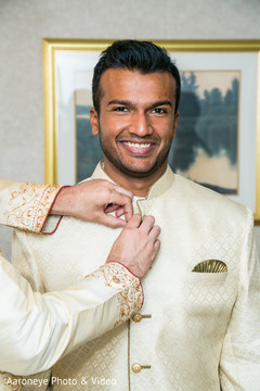 Indian groom being helped to get his sherwani. Indian groom being helped to get his sherwani.