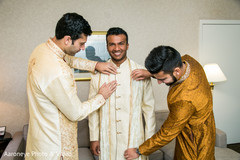 Indian groom being helped to get his dupatta on. Indian groom being helped to get his dupatta on.