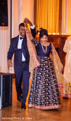 Glamorous Indian bride and groom walking in to wedding reception. Glamorous Indian bride and groom walking in to wedding reception.