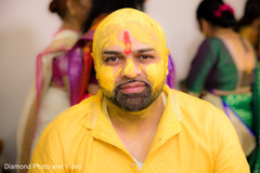 Indian groom is smeared in yellow turmeric paste Indian groom is smeared in yellow turmeric paste