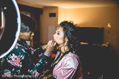 Indian bride getting makeup last touch ups for her wedding ceremony. Indian bride getting makeup last touch ups for her wedding ceremony.
