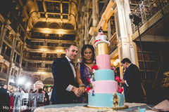 Cheerful Indian bride and groom cutting the cake. Cheerful Indian bride and groom cutting the cake.