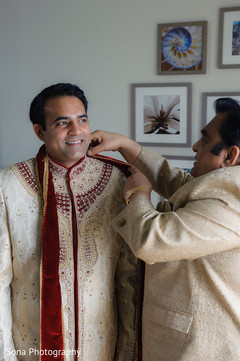 Indian groom being helped by parents to get ready Indian groom being helped by parents to get ready