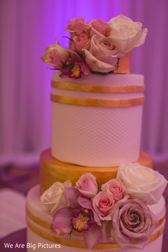 White and golden Indian wedding cake with flowers decoration. White and golden Indian wedding cake with flowers decoration.