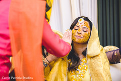 Lovely Indian bride getting turmeric paste on her face. Lovely Indian bride getting turmeric paste on her face.