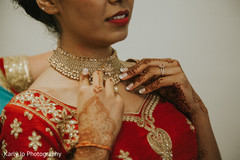 Indian bride being helped with jewelry Indian bride being helped with jewelry
