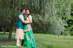 Lovely Indian couple outdoors on their sangeet traditional outfits. Lovely Indian couple outdoors on their sangeet traditional outfits.