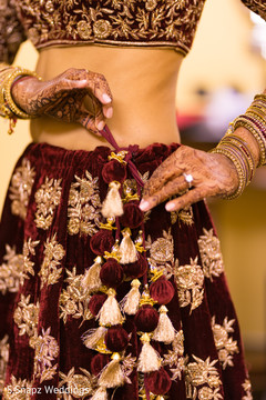 Indian bride getting her lengha tied up. Indian bride getting her lengha tied up.