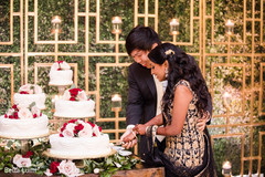 Lovely capture Indian bride and groom cutting cake together. Lovely capture Indian bride and groom cutting cake together.