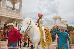 Elegant Indian groom on his white horse during the Baraat celebration. indian groom,indian wedding fashion,baraat,indian pre-wedding celebration