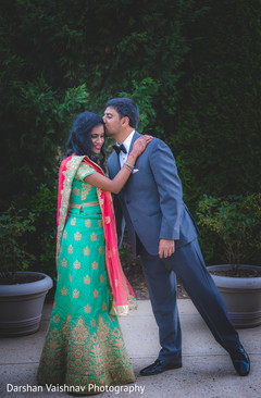 Adorable Indian bride being kissed by groom outdoor capture. indian bride and groom,indian wedding fashion,indian wedding hair and makeup