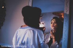 Indian bride getting her last touch ups of makeup. indian bride,indian bridal hair and makeup,indian wedding fashion,indian bridal jewelry
