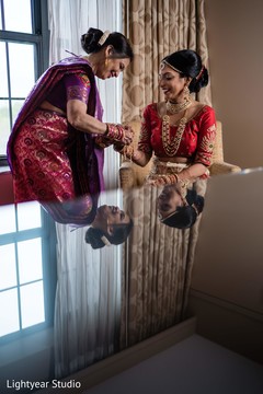 Indian bride being helped with jewelry indian wedding gallery,indian bride getting ready,indian bride fashion,bridal jewelry