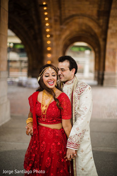 Indian bride and groom posing outdoors on their wedding ceremony outfits. indian bride and groom,indian wedding ceremony fashion