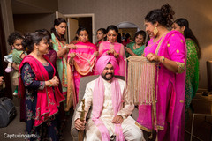 Indian groom being helped to get ready Indian groom being helped to get ready