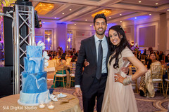 Lovely indian couple posing next to wedding cake Lovely indian couple posing next to wedding cake
