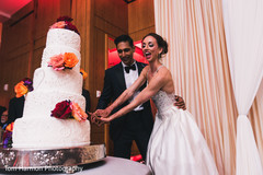 Joyful indian couple cutting their wedding cake Joyful indian couple cutting their wedding cake