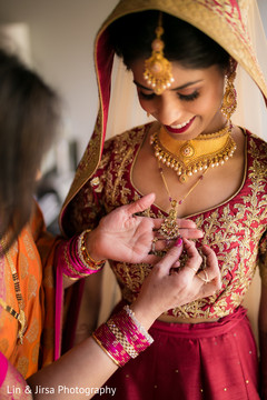 Indian bride being helped with jewelry Indian bride being helped with jewelry