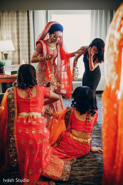 Indian bride getting help to put on her jewelry Indian bride getting help to put on her jewelry