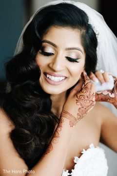 Indian bride putting earrings on Indian bride putting earrings on