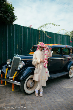 Elegant indian groom posing next to wedding car Elegant indian groom posing next to wedding car