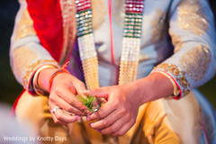 Closeup capture of Indian groom holding grass for wedding ritual. Closeup capture of Indian groom holding grass for wedding ritual.