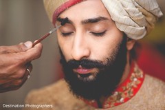 Indian groom being helped to get ready Indian groom being helped to get ready