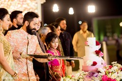 Indian newlyweds cutting the cake capture Indian newlyweds cutting the cake capture
