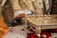 Indian bride touches with toe seven nuts or betel. Indian bride touches with toe seven nuts or betel.