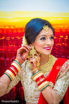 Indian bride putting earrings on Indian bride putting earrings on