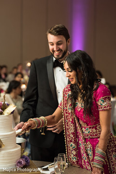 Lovely capture Indian bride and groom cutting cake together. Lovely capture Indian bride and groom cutting cake together.