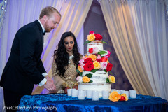 Indian newlyweds cutting the cake capture Indian newlyweds cutting the cake capture