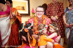 Lovely flower girls hugging the groom capture. Lovely flower girls hugging the groom capture.