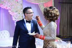 Indian bride giving the groom a taste of wedding cake. Indian bride giving the groom a taste of wedding cake.