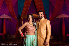 Joyful Indian bride and groom posing at their sangeet celebration. Joyful Indian bride and groom posing at their sangeet celebration.