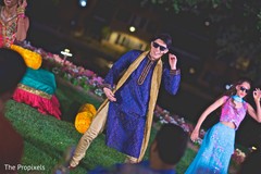 The Indian groom happily dances at the sangeet. The Indian groom happily dances at the sangeet.